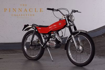 a red motorcycle parked in front of the pinnacle collection sign