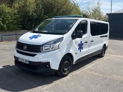 une camionnette blanche portant l'inscription « EMT » sur le côté, garée sur un parking