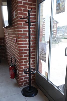 a black coat rack in front of a brick wall