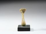 un gros plan d'une sculpture représentant un champignon sur un socle noir