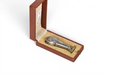 une cuillère en argent dans une boîte en bois posée sur une surface blanche