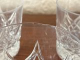 three glasses sitting on a table with a cloth behind them