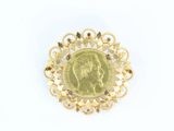 une image représentant une broche en or avec une pièce de monnaie au centre