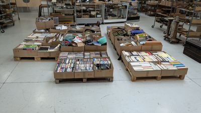 many boxes of books on the floor in a large room