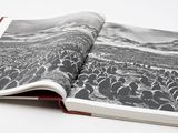 un livre ouvert sur lequel figure une photo en noir et blanc représentant une foule de personnes