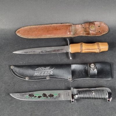 three different types of knives and a leather sheath on a table