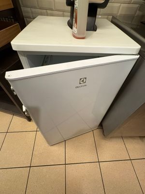 a coffee pot sitting on top of a small refrigerator