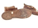 pair of brown leather shoes on a white surface with a white background