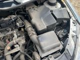 the engine of a car with its hood open on the side of the road