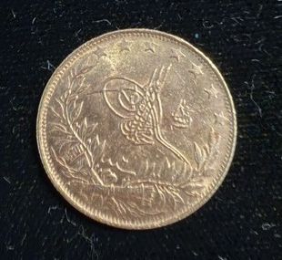 gros plan d'une pièce d'or sur une surface noire