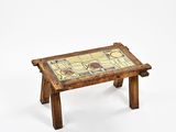 une petite table en bois recouverte d'un plateau en carrelage