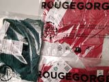 three pairs of red and green t - shirts are wrapped in plastic