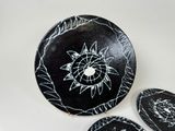 three plates with black and white designs on them