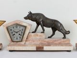 a statue of a dog and a clock on a table