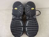 pair of black and gray shoes with yellow accents on a white surface