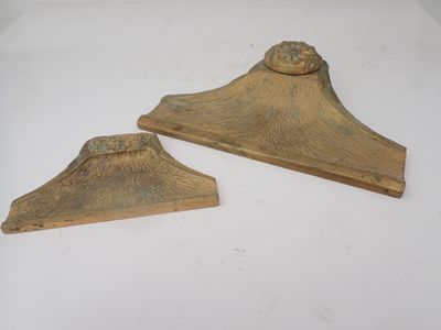 une paire de supports en laiton sur une surface blanche