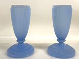 pair of blue glass vases sitting on top of a white table