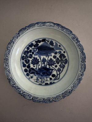 a blue and white plate with flowers and birds on it