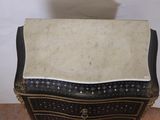 a small black and white chest with a marble top