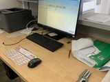 un bureau sur lequel se trouvent un ordinateur, un clavier, une souris et d'autres objets