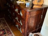 a dresser with a clock on top of it in a room