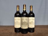 three bottles of wine sitting on top of a wooden table