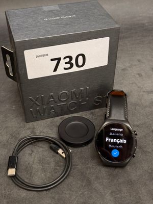 une montre connectée posée à côté d'un chargeur et d'un chargeur