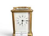 une petite horloge en or avec une clé sur le côté