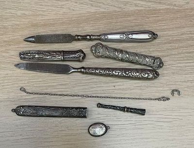 five different types of knives and a pocket watch on a table