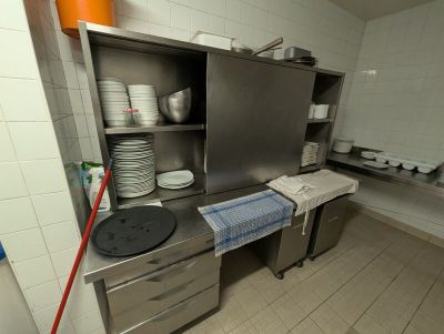 une cuisine où il y a beaucoup de vaisselle et de plats posés sur le plan de travail