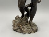 bronze statue of a man holding a fish on a rock