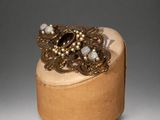 a close up of a wooden box with a ring on top of it