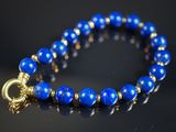 un gros plan sur un bracelet bleu muni d'un fermoir doré
