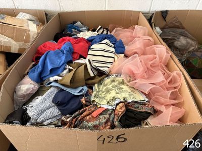 a cardboard box filled with lots of assorted clothing