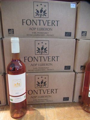 trois bouteilles de vin posées sur une table en bois, à côté de cartons de vin