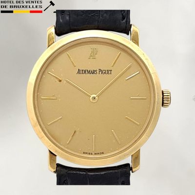 an image of a gold wrist watch with a black leather strap