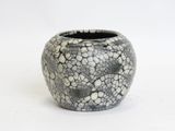 a black and white vase sitting on a white surface