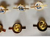three gold and silver cuff rings with a blue and white logo