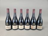 six bottles of wine are lined up in a row on a table