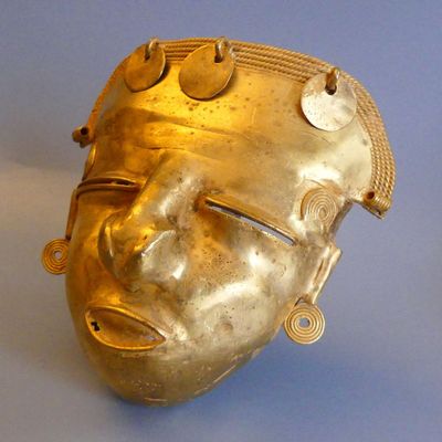 a gold mask on a blue surface with a blue background