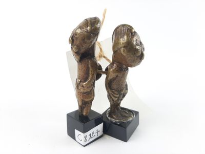 two figurines of a man and a woman holding hands