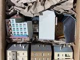 une boîte en carton remplie de petites maquettes de maisons et de bâtiments