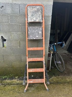 une échelle appuyée contre un mur, à côté d'un vélo