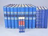 six livres bleus sont alignés sur une surface blanche