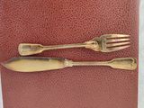 two forks and a spoon on a red book