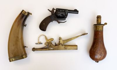 trois types d'armes à feu différents posés sur une surface blanche