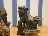 two statues of dogs on a table next to a bowl