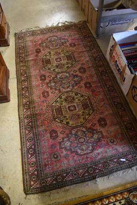 un tapis posé à même le sol dans une pièce où se trouvent de nombreux cartons remplis de livres