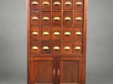 une armoire ancienne en bois comportant de nombreux tiroirs et portes