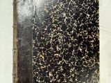 un gros plan d'un livre à la couverture noire posé sur une surface blanche